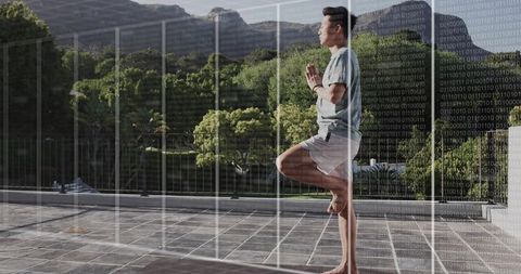 Practicing Yoga Tree Pose on Terrace with Digital Grid Overlay and Fitness Tracker