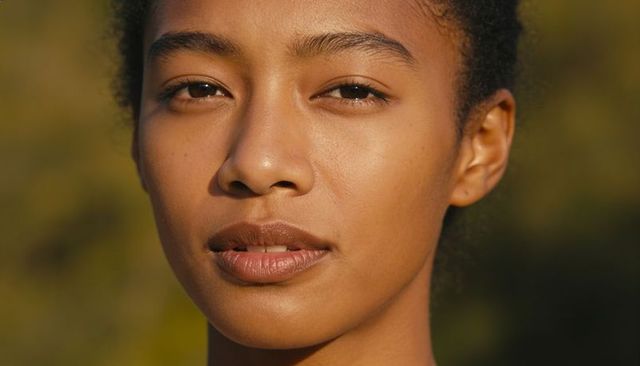 Closeup woman gazing in golden hour light showing natural skin texture