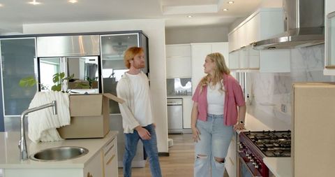 Happy Couple Touring Modern Kitchen During House Move