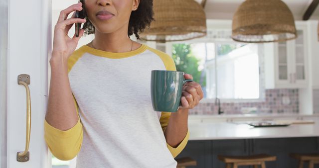 Woman Talking on Phone While Holding Coffee Mug in Modern Kitchen - Download Free Stock Images Pikwizard.com