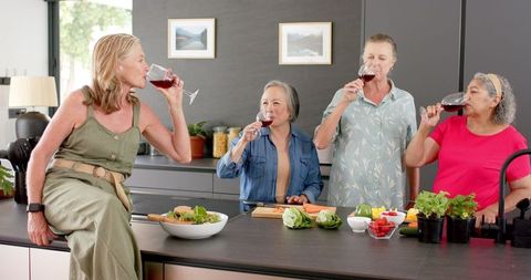 Senior Women Enjoying Wine in Contemporary Kitchen