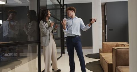 Celebrating Success: Colleagues High-Fiving in Modern Office