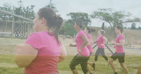Group of Women Jogging Together in Pink Activewear in a Park