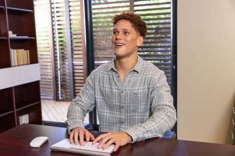 Young Professional Typing Joyfully in Modern Workspace