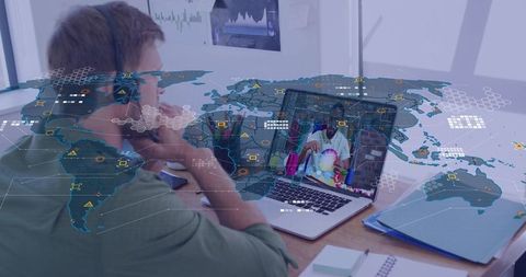 Man wearing headset studying on laptop with global network overlay for remote collaboration