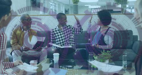 Team of diverse colleagues celebrating in modern office lounge