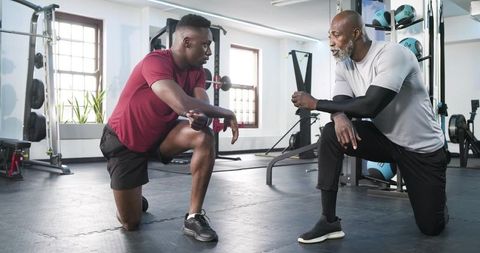 African american fitness coach guiding client during workout session