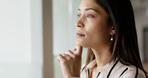 Thoughtful Businesswoman Gazing Out Office Window