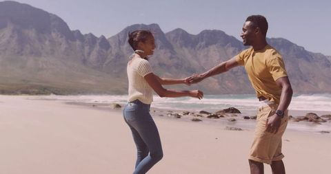 Couple enjoying romantic beach adventure by scenic mountains