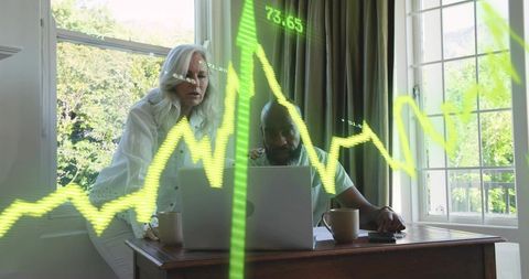 Senior Couple Collaborating on Finances at Home Office with Neon Stock Chart Overlay