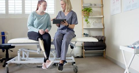 Therapist discussing treatment with woman with prosthetic leg