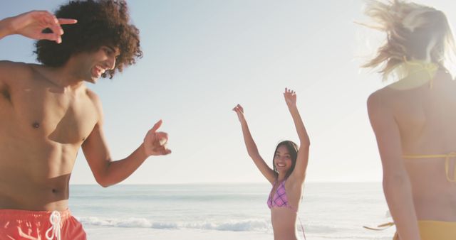 Young friends are seen having fun at the beach, with bright sunlight creating a joyful atmosphere. Ideal for advertisements promoting summer activities, vacation packages, beachwear, and outdoor lifestyle. Perfect for illustrating articles about summer, travel experiences, and the joy of social connections.