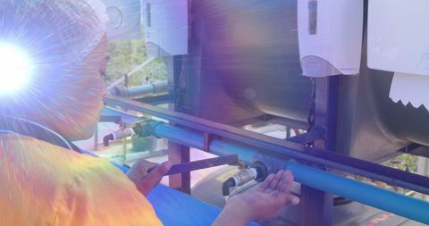 Lens flare on woman washing hands at outdoor standpipe