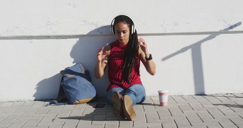 Young Woman Enjoying Music Outdoors in Casual Attire