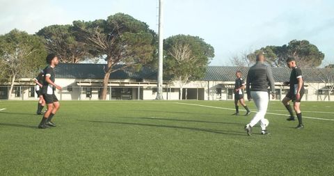Soccer Coach Instructing Players During Outdoor Team Practice
