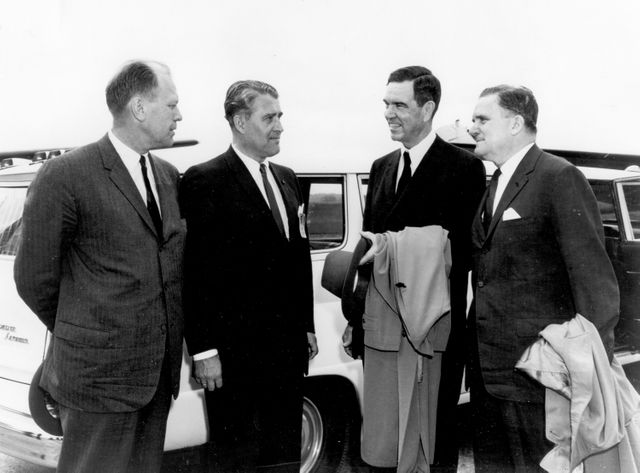 Historical moment captured at Marshall Space Flight Center in 1964 featuring Congressmen Gerald Ford Jr. and George H. Mahon, along with NASA Administrator James E. Webb and MSFC director Dr. Wernher von Braun. This image can be used in documents or websites covering American history, space exploration during the 1960s, or profiles of influential government and scientific figures involved in the Apollo program. Ideal for educational materials, documentaries, and articles discussing early NASA initiatives.