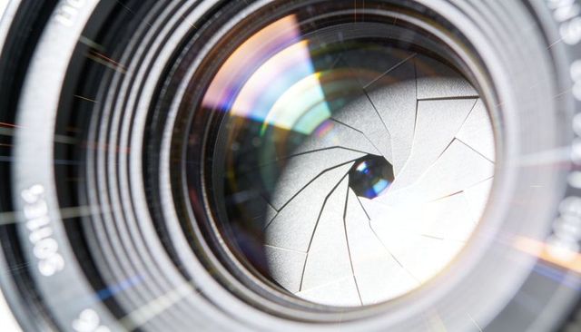 Macro camera lens showing aperture blades, spiral shutter and optical reflections