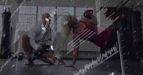 Female athlete performing kettlebell rotating plank while coach tracking metrics on tablet