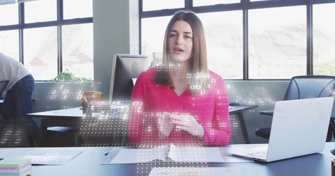 Businesswoman presenting data overlay during collaborative meeting in modern office