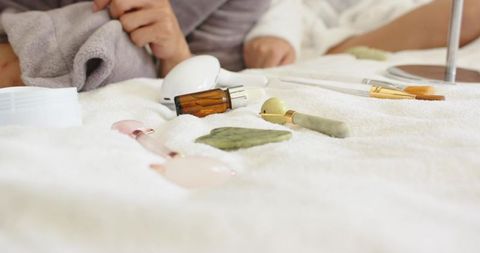 Couple enjoying at-home spa with jade roller, gua sha and facial tools on plush towel