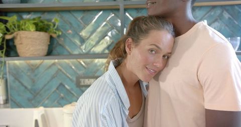 Interracial Couple Embracing in Modern Kitchen at Home