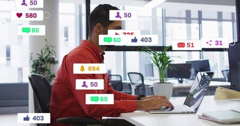 Young professional typing on laptop with social overlays in coworking office