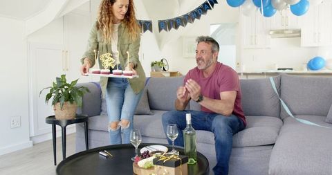 Couple Celebrating Birthday with Cupcakes and Wine in Living Room
