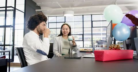 Colleagues enjoying coffee break in decorated office