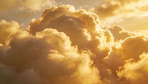 Golden cumulus cloudscape with rim lighting, warm sunset glow, fluffy atmospheric texture