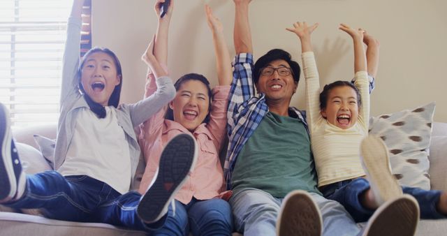 Happy Family Enjoying Together Time on Couch With Raised Arms - Download Free Stock Images Pikwizard.com