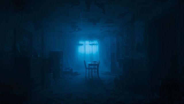 Blue-lit abandoned interior showing lone wooden table and chairs in derelict room