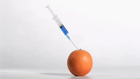 Syringe Injecting Orange Symbolizing Medical Experimentation