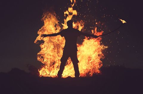 Silhouette of Person with Fire in Nighttime Dramatic Scene