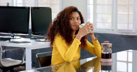 Smiling Woman Enjoying Coffee Break in Modern Office