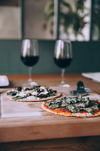 Gourmet Vegetarian Pizza Pairing with Red Wine on Rustic Table