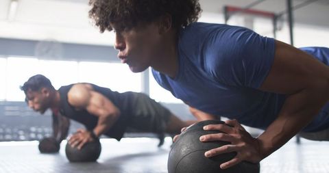 Men Doing Push-Ups on Medicine Balls During Intense Gym Session