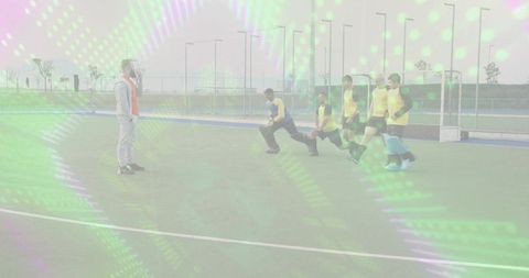 Field hockey coach leading defensive lunging drill with goalkeeper and five players