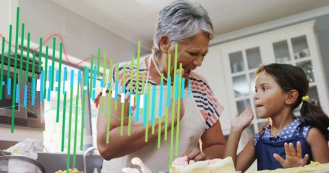 Aproned grandmother baking cupcakes with granddaughter in cozy kitchen with chart overlay