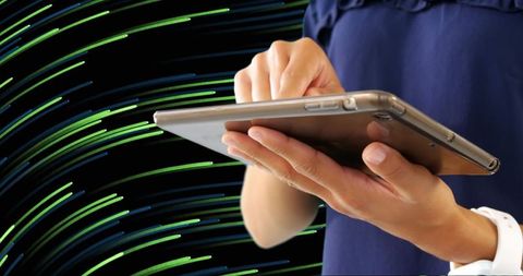 Person Navigating Tablet with Dynamic Light Trails in Background