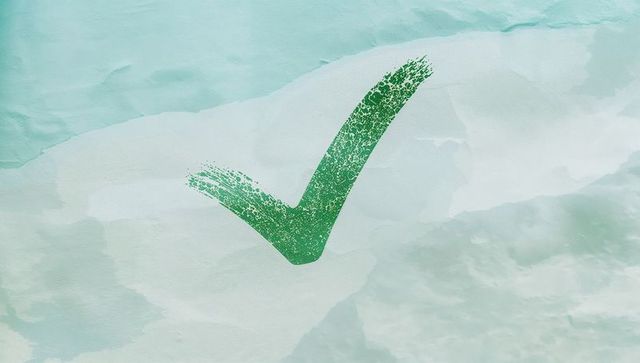 Textured green check mark on watercolor background