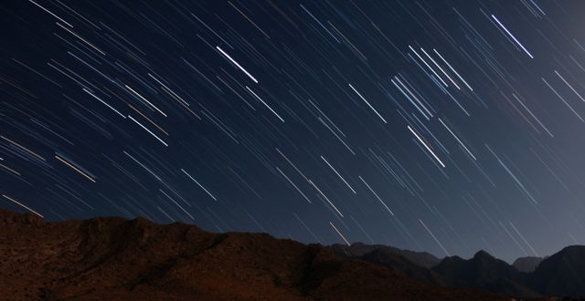 Starry Night Sky with Time-lapse Star Trails over Mountain Landscape - Download Free Stock Photos Pikwizard.com