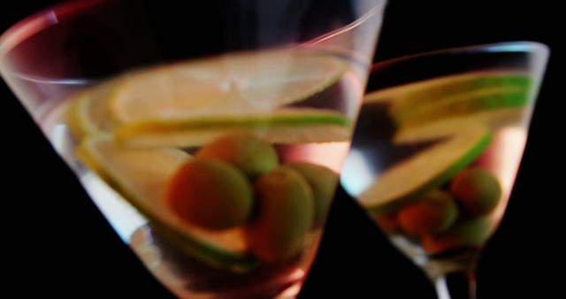 Close-Up Gleaming Martini Glasses with Olives and Lime Slices on Black Background - Download Free Stock Images Pikwizard.com