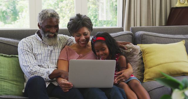 Happy Grandparents Watching Video with Granddaughter on Sofa - Download Free Stock Images Pikwizard.com