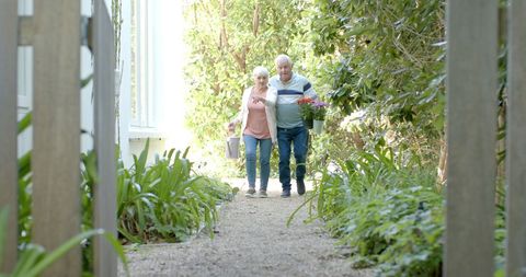 Senior Couple Walking in Garden Carrying Flowers Full of Love - Download Free Stock Images Pikwizard.com