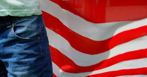 Caucasian schoolboy holding american flag in schoolyard