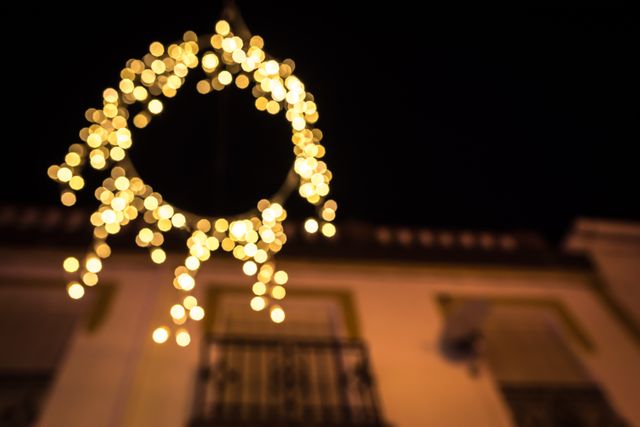 Image of blurred circular string lights hanging outdoors at night, capturing a bokeh effect. Suitable for backgrounds, holiday and festive themes, marketing materials, or website banners emphasizing celebration and decoration.