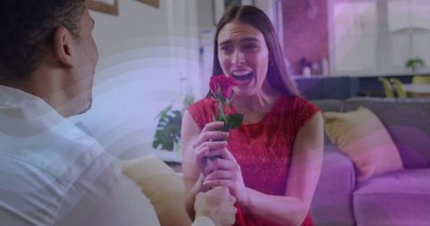 Man offering red rose to surprised woman in living room
