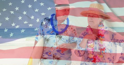 Senior Couple Enjoying Beach In Front of American Flag