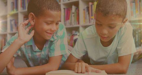 Biracial Boys Reading Books Lying on Carpet