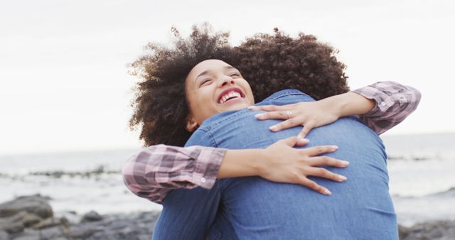 African american woman hugging her husband on the rocks near the sea. love and relationship concept